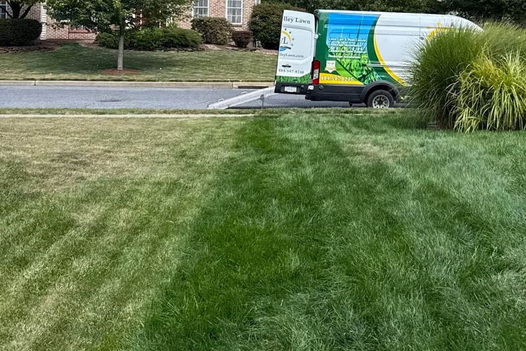 Lawn care service truck parked on well-maintained garden lawn at Herbein's Garden Center.