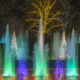 Colorful illuminated fountain at Herbein's Garden Center during evening.