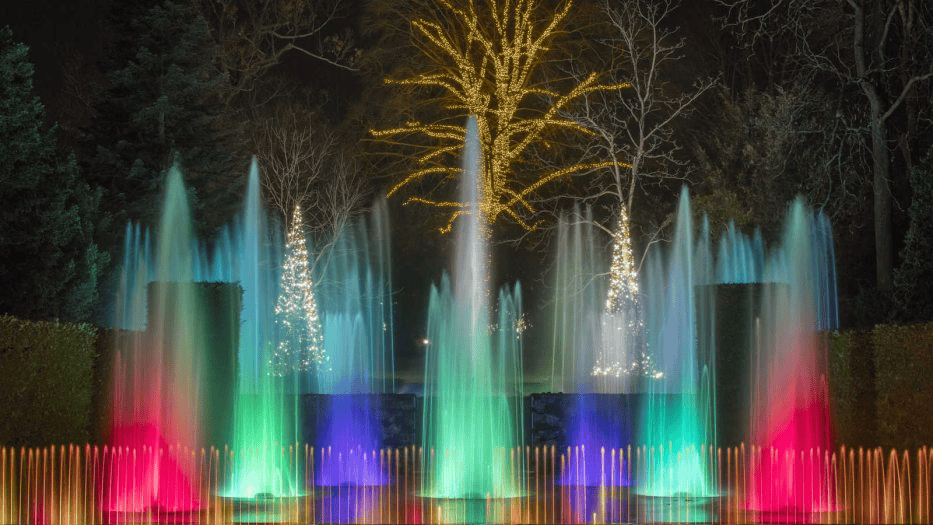 Colorful illuminated fountain at Herbein's Garden Center during evening.