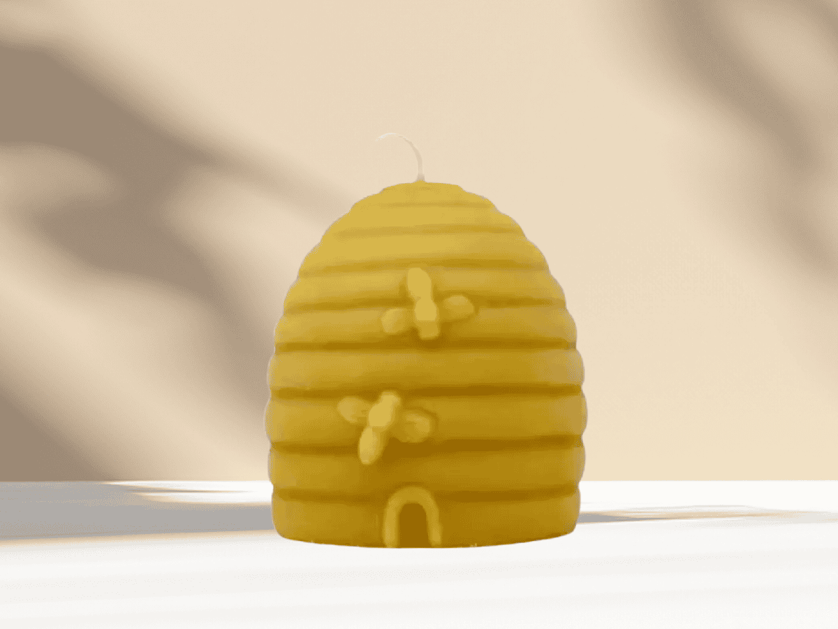 Yellow bee hive shaped candle with bees decoration, decorative home accessory, perfect for garden or nature-themed decor.
