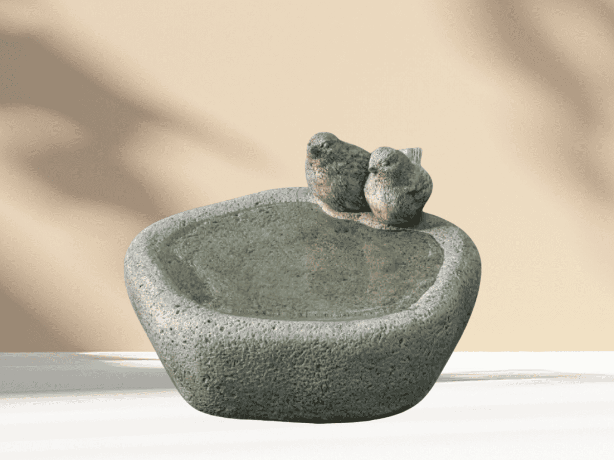 Stone bird bath with two birds on edge, perfect for gardens and outdoor decor.